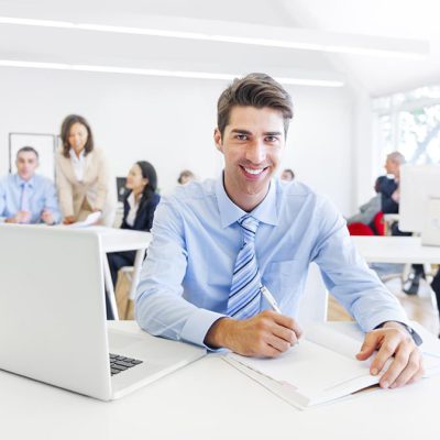 Cheerful Corporate Businessman Working with His Paperworks and Laptop